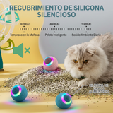 Gato gris observando dos KeraBall de colores rosa y azul iluminadas sobre una alfombra